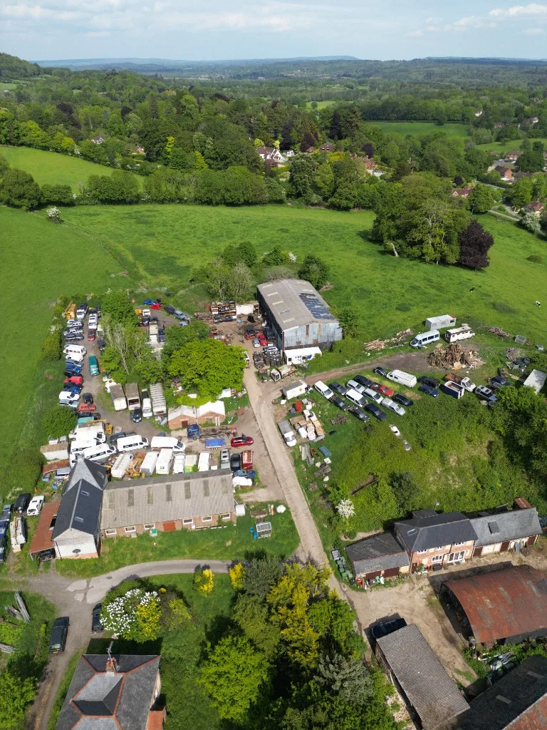 Closer aerial view of vehicles and buildings at Steep Salvage